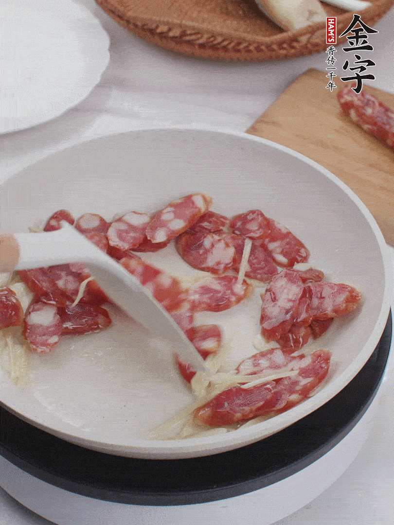 油溫3成熱時，下姜絲、蒜片、香腸炒出油脂。